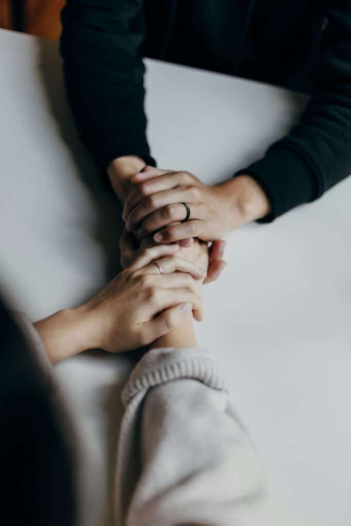 Two people holding hands during a supportive consultation at Integria Precision Medicine